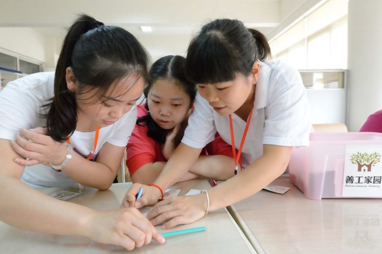 成都善工家园大学生志愿者张国先工作人员在专心致志交学生上课中物院袁义芳摄DSC_0544_225_JPG