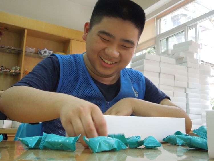 轻度智力障碍残疾人在进行牛轧糖包装_JPG